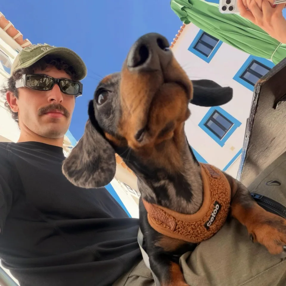 A dachshund and community member enjoying a sunny moment in Ericeira